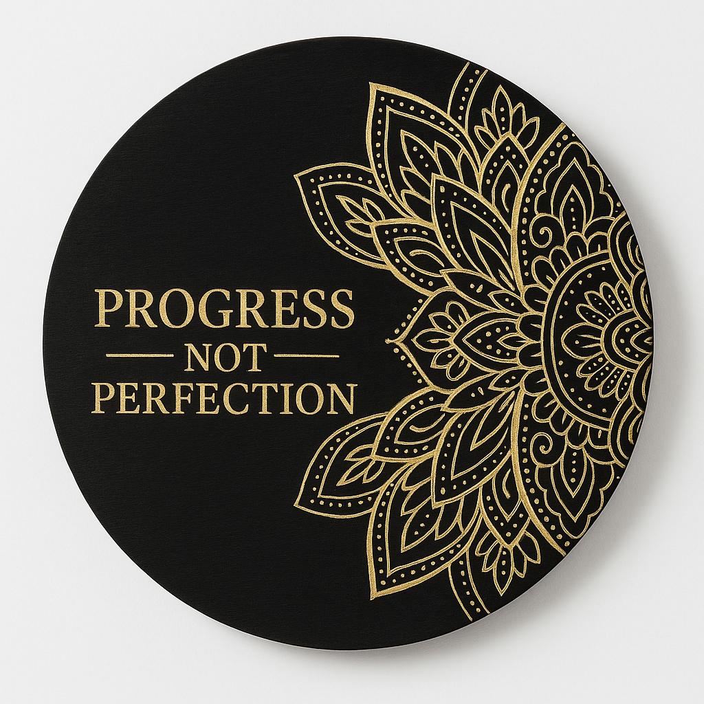 Decorative plate with gold mandala design and 'Progress Not Perfection' text on a black background